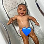 baby, bathtub, bath, water, bubbles, smiling, happy, child, infant, skin, wet, baby_seat, arm, leg, face, hand, bathroom, tub, blue_heart_emoji, bracelet