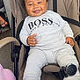 Drayton-Reign is registered to the contest to win money with this photo: baby, child, smiling, stroller, white_shoes, white_clothing, curly_hair, happy, seated, indoor, cute, fashion, footwear, person, infant, casual_wear, modern, comfortable, portrait, joyful