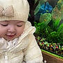 baby, child, infant, white_hat, bow, jacket, aquarium, fish, glass, plants, colorful, smiling, cute, indoor, hand, candid, portrait, warm_clothing, happy, closeup