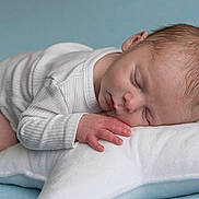 Lény participe au concours pour gagner de l'argent avec cette photo : baby, newborn, sleeping, white_onesie, pillow, star_shaped_pillow, peaceful, infant, soft, cozy, cute, child, resting, portrait, indoors, closeup, head, hand, skin, sleep