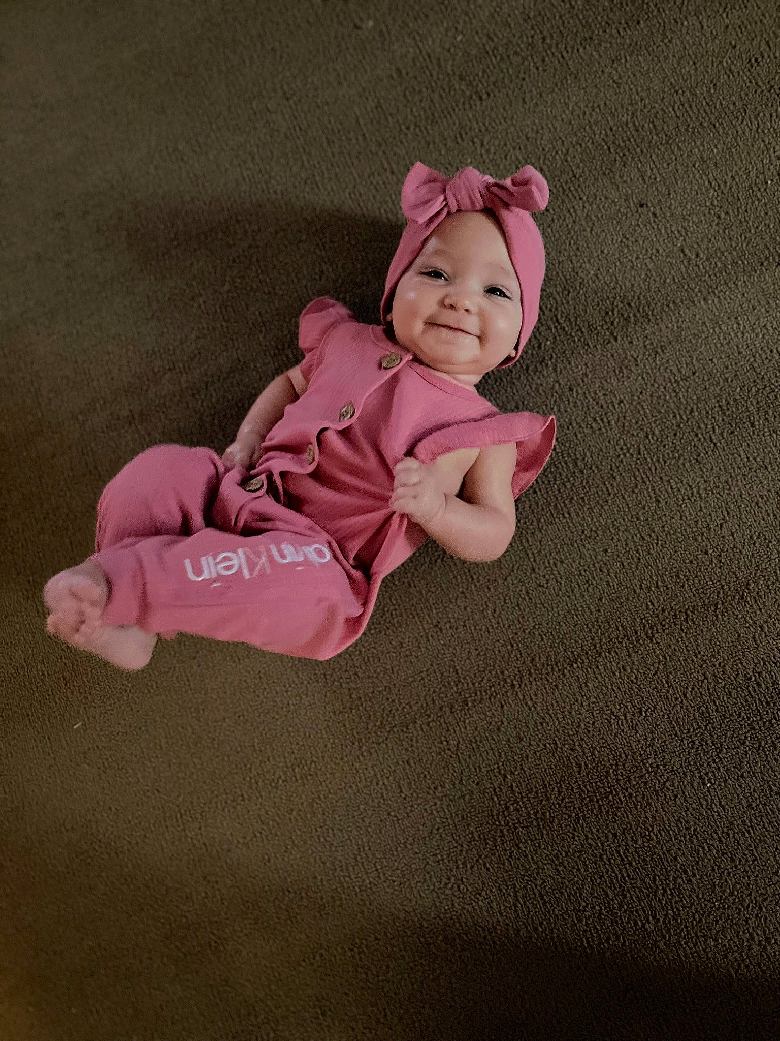 Ivy is registered to the contest to win money with this photo: baby, baby_products, baby_toddler_clothing, child, circle, comfort, flooring, happy, headwear, joy, linens, magenta, pattern, person, sitting, sleeve, smile, toddler