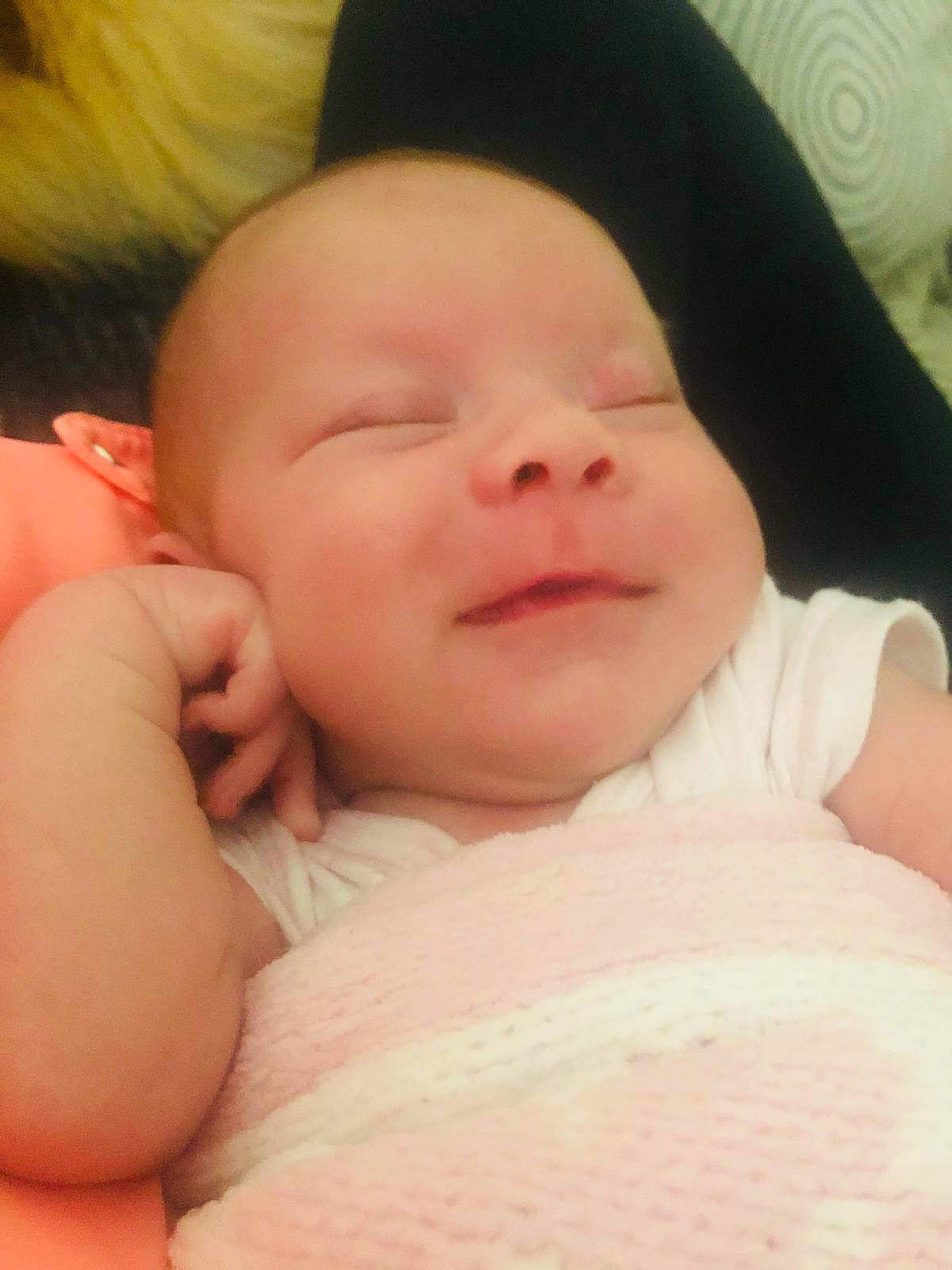 Olivia is registered to the contest to win money with this photo: baby, cheek, chin, comfort, eye, eyebrow, facial_expression, finger, gesture, head, iris, lip, mouth, neck, nose, person, pink, skin, smile, thumb