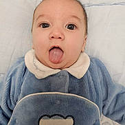 Maël a rejoint le concours — aidez-le/la à gagner de superbes lots ! baby, infant, tongue_out, blue_outfit, cute, close_up, face, expression, lying_down, blanket, child, adorable, soft_texture, warm_clothing, person, young, portrait, indoor, head, skin