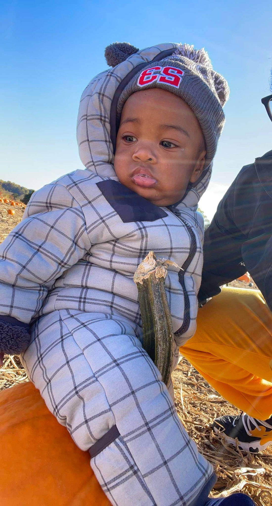 Jonathon is registered to the contest to win money with this photo: baby, baseball_cap, cap, child, fun, grass, happy, headgear, headwear, jacket, landscape, leisure, pattern, people_in_nature, person, plaid, plant, recreation, sky, toddler