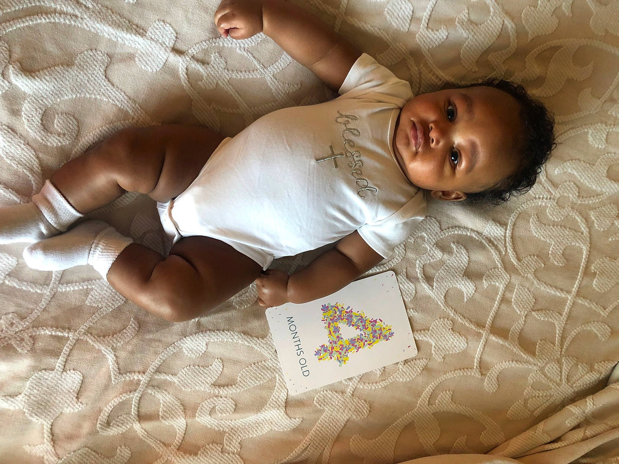 Carlos is registered to the contest to win money with this photo: abdomen, baby, bedding, chest, comfort, elbow, happy, human_body, human_leg, knee, leg, linens, pattern, person, room, skin, smile, textile, thigh, toddler