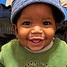 baby, child, smiling, hat, blue_hat, green_shirt, construction_truck, cute, portrait, face, happy, indoors, closeup, toddler, clothing, person, headwear, joyful, young_child, expressive