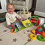 baby, child, smiling, play_mat, toys, book, indoor, armchair, basket, colorful, floor, happy, cute, infant, pajamas, room, playtime, development, early_learning, portrait
