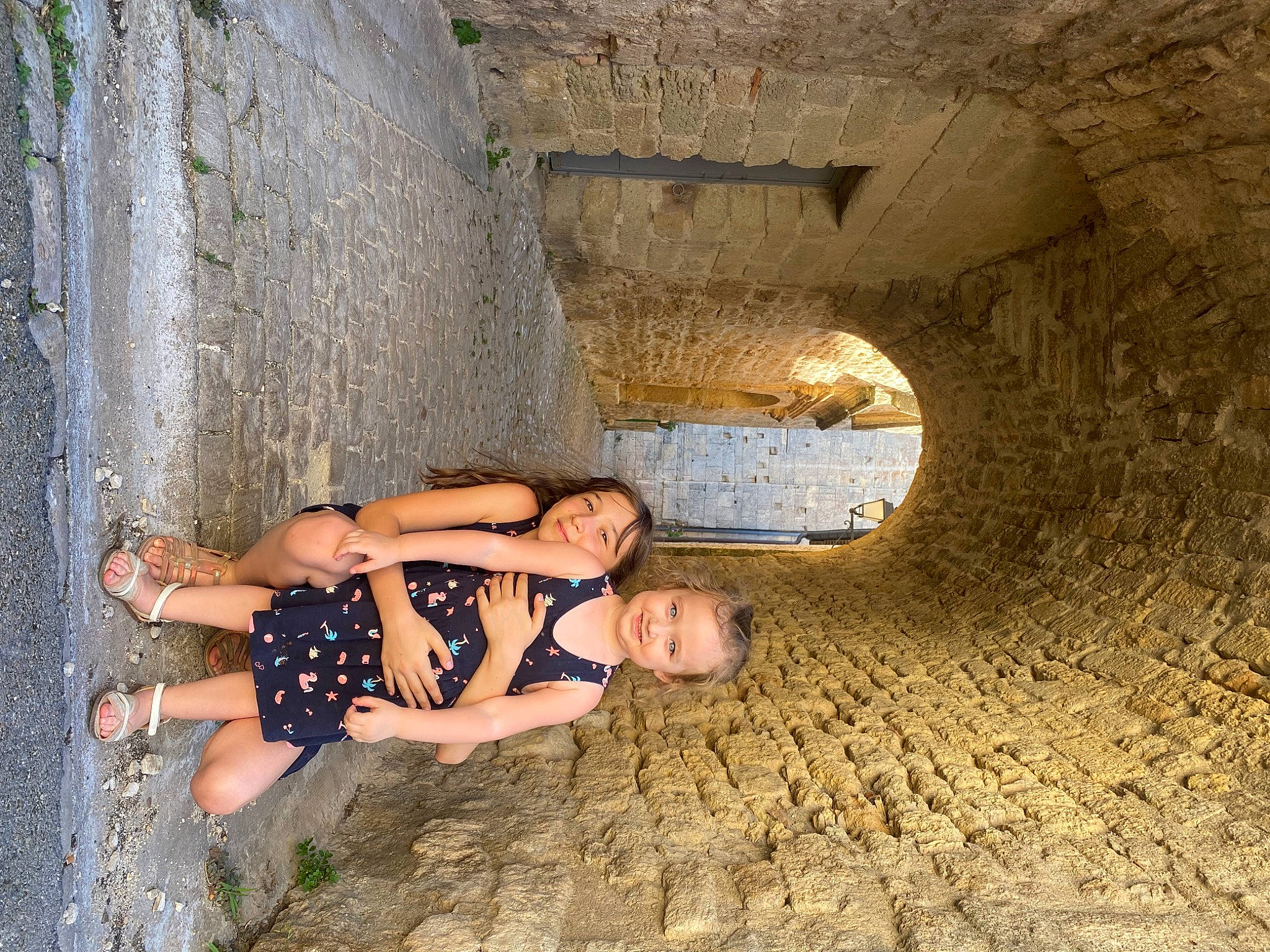 Lola Andréa a rejoint le concours — aidez-le/la à gagner de superbes lots ! arch, barechested, barefoot, concrete, flash_photography, foot, fun, human_leg, joy, landscape, leisure, person, recreation, rock, shadow, shorts, sitting, smile, thigh, toe