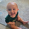 baby, child, smiling, sitting, carpet, green_shirt, indoors, cute, happy, face, legs, eyes, skin, infant, person, young_child, floor, expression, portrait, casual