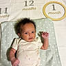 Rayla joined the competition — help win amazing prizes! baby, infant, one_month, blanket, star_pattern, wooden_ring, clothing, cute, lying_down, raising_hand, newborn, face, expression, bed, soft_texture, child, indoors, small_hand, hair, one_month_marker