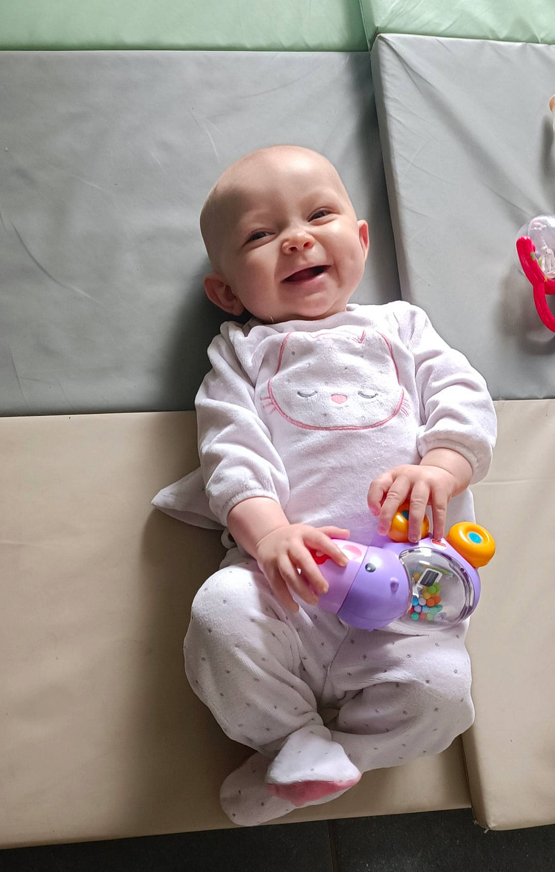 Maïna participe au concours pour gagner de l'argent avec cette photo : baby, baby_products, baby_toddler_clothing, cheek, child, comfort, flooring, foot, fun, happy, head, knee, person, pink, purple, sitting, skin, sleeve, smile, toddler