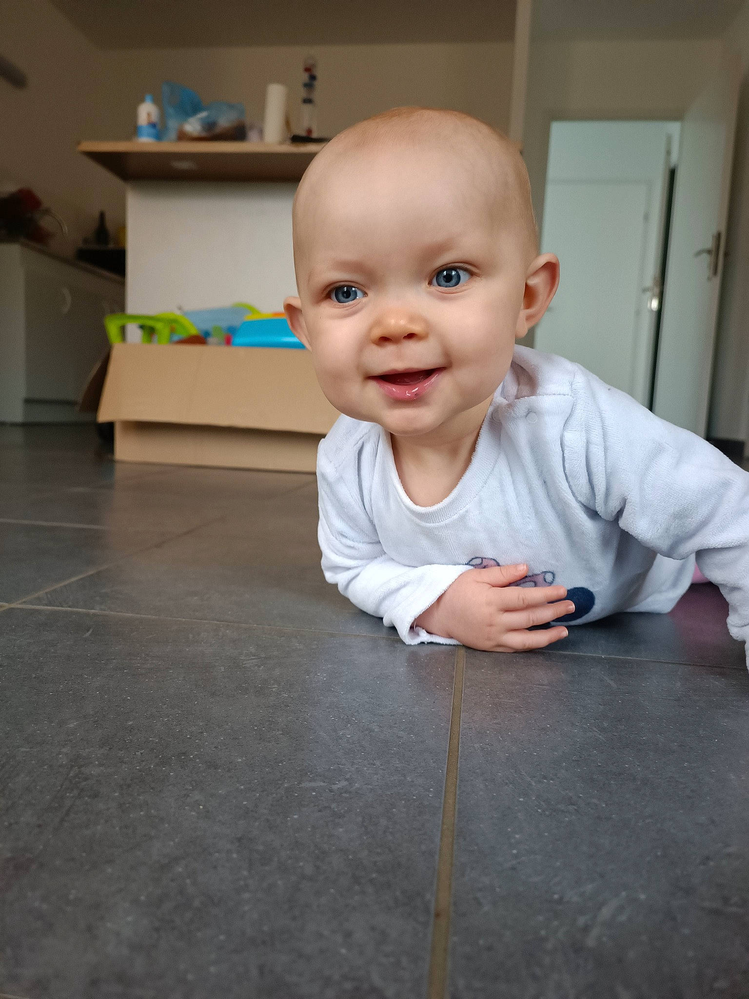 Maïna a rejoint le concours — aidez-le/la à gagner de superbes lots ! baby, baby_toddler_clothing, cheek, child, chin, door, eyebrow, floor, flooring, fun, gesture, hardwood, iris, joy, mouth, nose, person, skin, smile, standing
