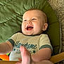 Emerson joined the competition — help win amazing prizes! baby, infant, smiling, laughing, green_cushion, shirt, handwritten_text, foot, carpet, indoor, cute, child, person, happy, playful, closeup, portrait, skin, furniture, relaxed