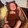 newborn, baby, infant, sleeping, brown_outfit, bear_ears, basket, wool, soft_texture, cozy, cute, sleep, indoors, portrait, baby_clothing, peaceful, closeup, child, resting, warm_lighting