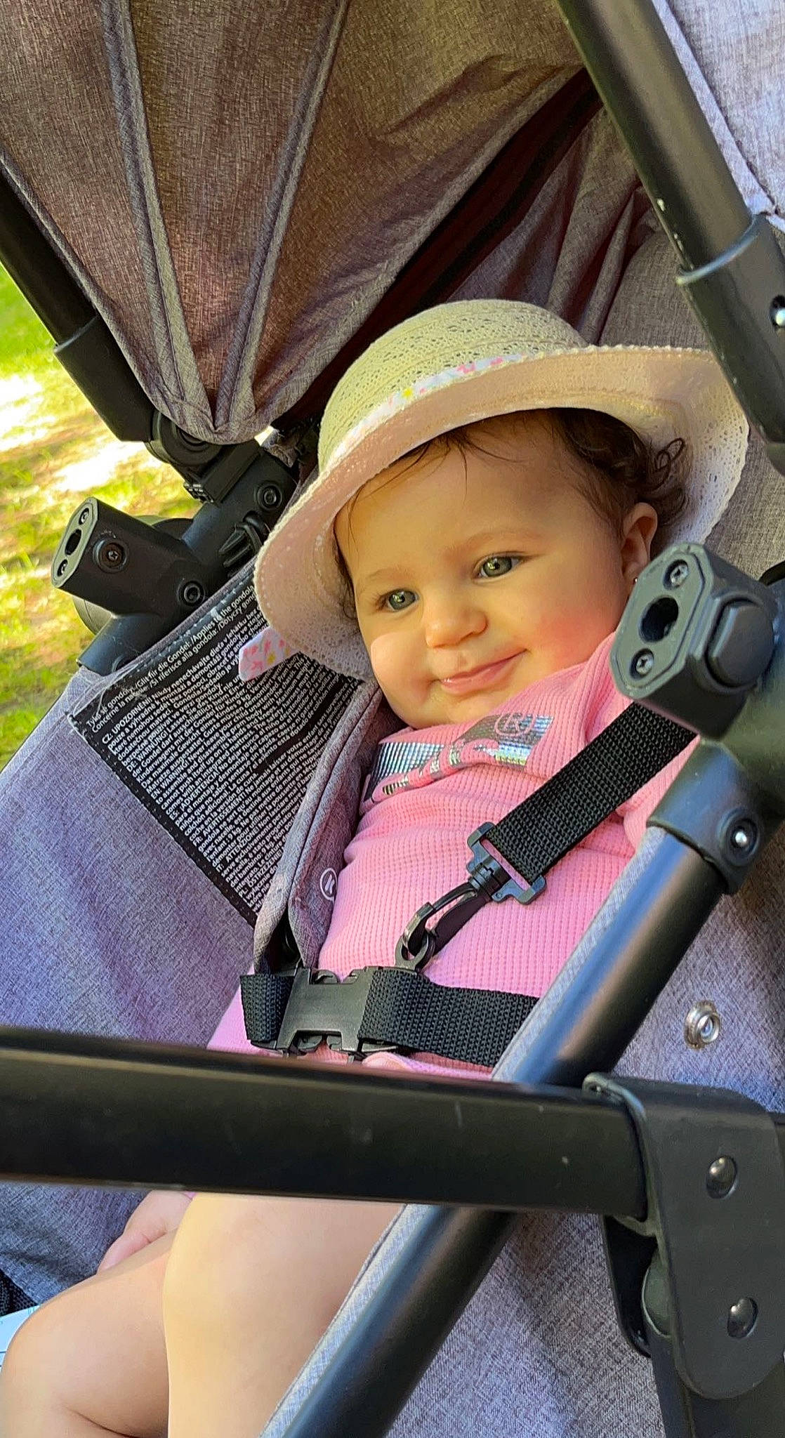 Emna a rejoint le concours — aidez-le/la à gagner de superbes lots ! auto_part, baby, baby_carriage, baby_products, baby_safety, baby_toddler_clothing, child, facial_expression, fashion_accessory, fun, hat, headwear, person, sitting, smile, sun_hat, toddler, travel