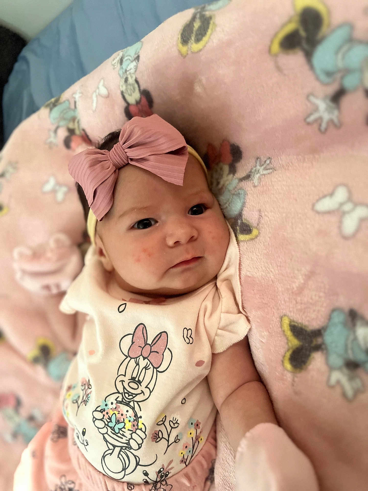 Dalila joined the competition — help win amazing prizes! baby, infant, pink_bow, headband, minnie_mouse, blanket, clothing, cute, face, portrait, lying_down, soft_toys, child, indoor, apparel, baby_mittens, expression, young_child, cartoon_character, cozy