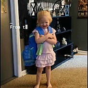 Ariah joined the competition — help win amazing prizes! child, toddler, girl, standing, smiling, barefoot, indoors, carpet, portrait, happy, clothing, dress, pink, blue, toy, bag, wall_decor, shelves, furniture, home