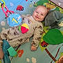 baby, infant, smiling, playpen, toy, blanket, colorful, onesie, cute, child, face, hand, fabric, pattern, indoor, happy, soft, comfort, lying, playtime