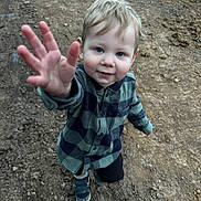 Tate is registered to the contest to win money with this photo: child, toddler, boy, outdoor, dirt, path, blue_eyes, checkered_shirt, long_sleeve, shoes, reaching_hand, curious, young, smiling, standing, nature, casual_clothing, portrait, daylight, playful