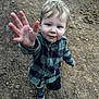 child, toddler, boy, outdoor, dirt, path, blue_eyes, checkered_shirt, long_sleeve, shoes, reaching_hand, curious, young, smiling, standing, nature, casual_clothing, portrait, daylight, playful