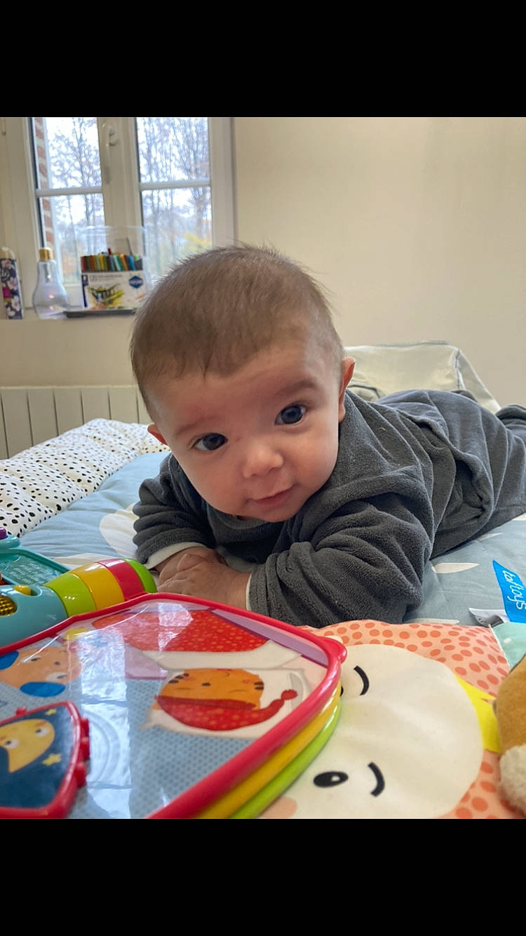 Ambrose participe au concours pour gagner de l'argent avec cette photo : baby, baby_playing_with_toys, baby_toddler_clothing, cheek, child, comfort_food, facial_expression, flooring, fun, iris, mouth, person, play, product, sharing, sitting, sweetness, t_shirt, textile, toddler