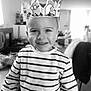 Aykan a rejoint le concours — aidez-le/la à gagner de superbes lots ! child, boy, smile, striped_shirt, paper_crown, minions, indoor, portrait, happy, face, eyes, hair, clothing, young, person, cute, home, furniture, background, black_and_white