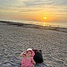 Chanel Leigh is registered to the contest to win money with this photo: baby, beach, sunset, sand, ocean, blanket, hat, pink_clothing, child, bag, sunlight, outdoor, nature, sky, water, vacation, summer, portrait, sitting, relaxation