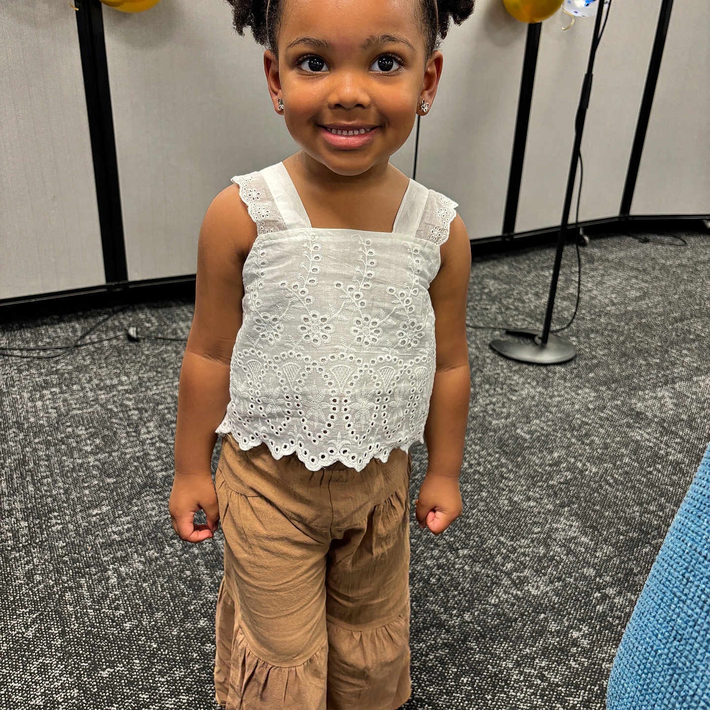 Aubri joined the competition — help win amazing prizes! balloons, brown_pants, carpet, celebration, child, curly_hair, cute, decorations, earrings, event, girl, happy, headband, indoor, people, portrait, sandals, smiling, standing, white_top
