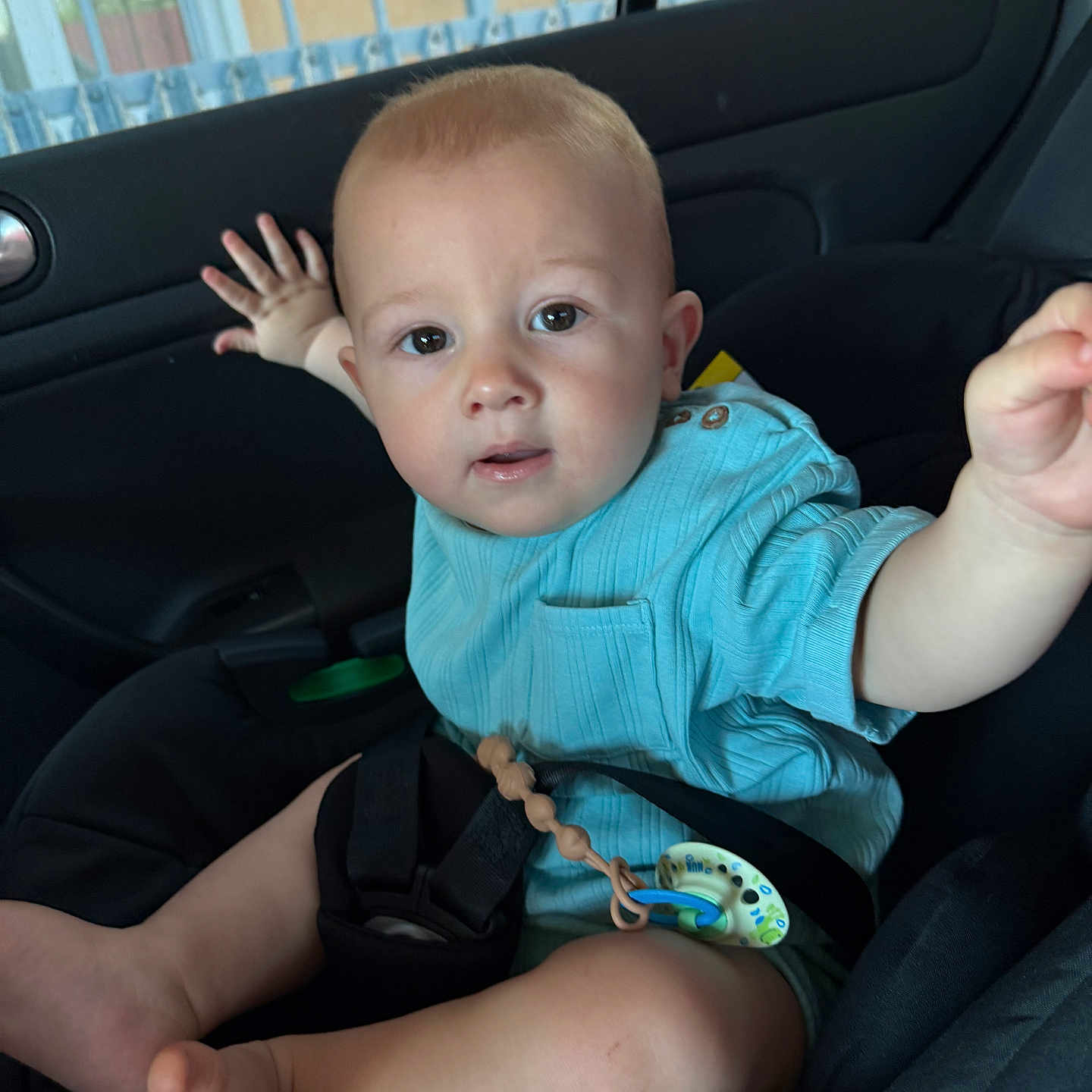 Dominic Nicolas is registered to the contest to win money with this photo: baby, blue_shirt, car_interior, car_seat, casual, child, curious, cute, expression, face, foot, infant, inside_car, legs, pacifier, portrait, reaching_hand, safety, seatbelt, young_child