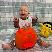 Dominic Nicolas is registered to the contest to win money with this photo: baby, child, pumpkin, jack_o_lantern, halloween, plush_toy, yellow_toy, pajamas, smiling, sitting, blanket, carved_pumpkin, glowing, indoor, cute, festive, happy, orange, face, toy