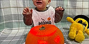 Dominic Nicolas is registered to the contest to win money with this photo: baby, child, pumpkin, jack_o_lantern, halloween, plush_toy, yellow_toy, pajamas, smiling, sitting, blanket, carved_pumpkin, glowing, indoor, cute, festive, happy, orange, face, toy
