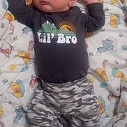 Zedadiah. is registered to the contest to win money with this photo: baby, blanket, camouflage, child, clothing, comfort, cute, footwear, indoors, infant, lying_down, patterned, peaceful, person, resting, sleeping, small, smile, soft, toddler