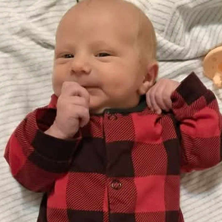 Zedadiah. joined the competition — help win amazing prizes! baby, blanket, checkered_pattern, child, cute, expression, face, hand, head, indoors, infant, lying_down, newborn, onesie, portrait, red_clothing, skin, sleepwear, smile, striped