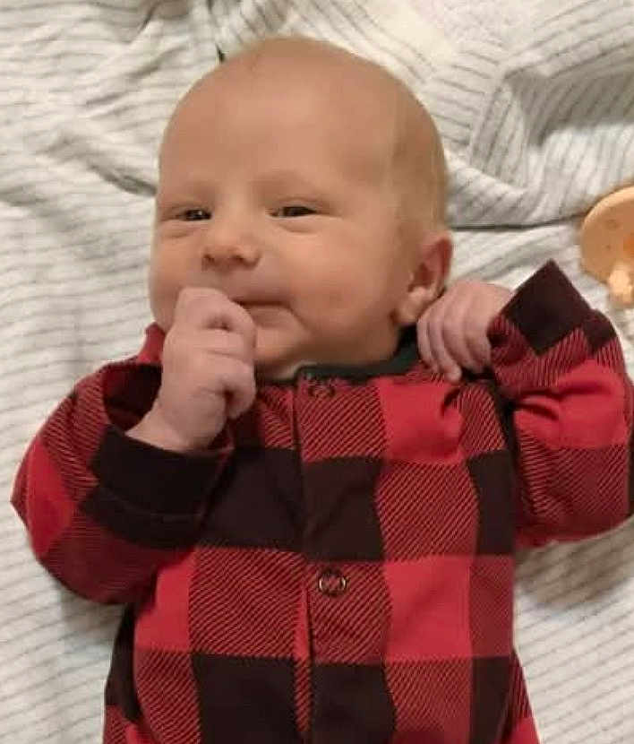 Zedadiah. joined the competition — help win amazing prizes! baby, infant, child, red_clothing, checkered_pattern, onesie, blanket, striped, hand, face, smile, cute, lying_down, indoors, newborn, skin, head, portrait, sleepwear, expression