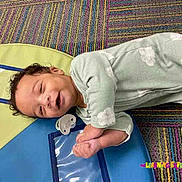 Javan Criswell joined the competition — help win amazing prizes! baby, infant, smiling, lying_down, onesie, carpet, colorful, playmat, child, happy, face, cute, indoors, floor, small_person, cartoon_koala, learning_center, soft_clothing, relaxed, playful