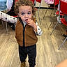 Adam joined the competition — help win amazing prizes! toddler, child, curly_hair, brown_vest, indoor, flooring, table, chair, people, snack, boots, long_sleeve_shirt, casual_clothing, young_child, event, gathering, red_chairs, wood_floor, people_sitting, curious
