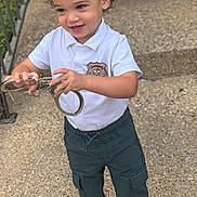 Adam joined the competition — help win amazing prizes! badge, child, concrete, curly_hair, cute, daylight, fun, handcuffs, outdoor, pants, person, play, police_costume, smile, sneakers, standing, steps, toddler, white_shirt, young_child