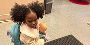 Adhara joined the competition — help win amazing prizes! child, girl, pigtails, backpack, doll, coat, sneakers, floor_mat, mailboxes, trash_bin, door, christmas_tree, holiday_decor, indoor, tile_floor, curly_hair, winter_clothing, toy, waiting, portrait