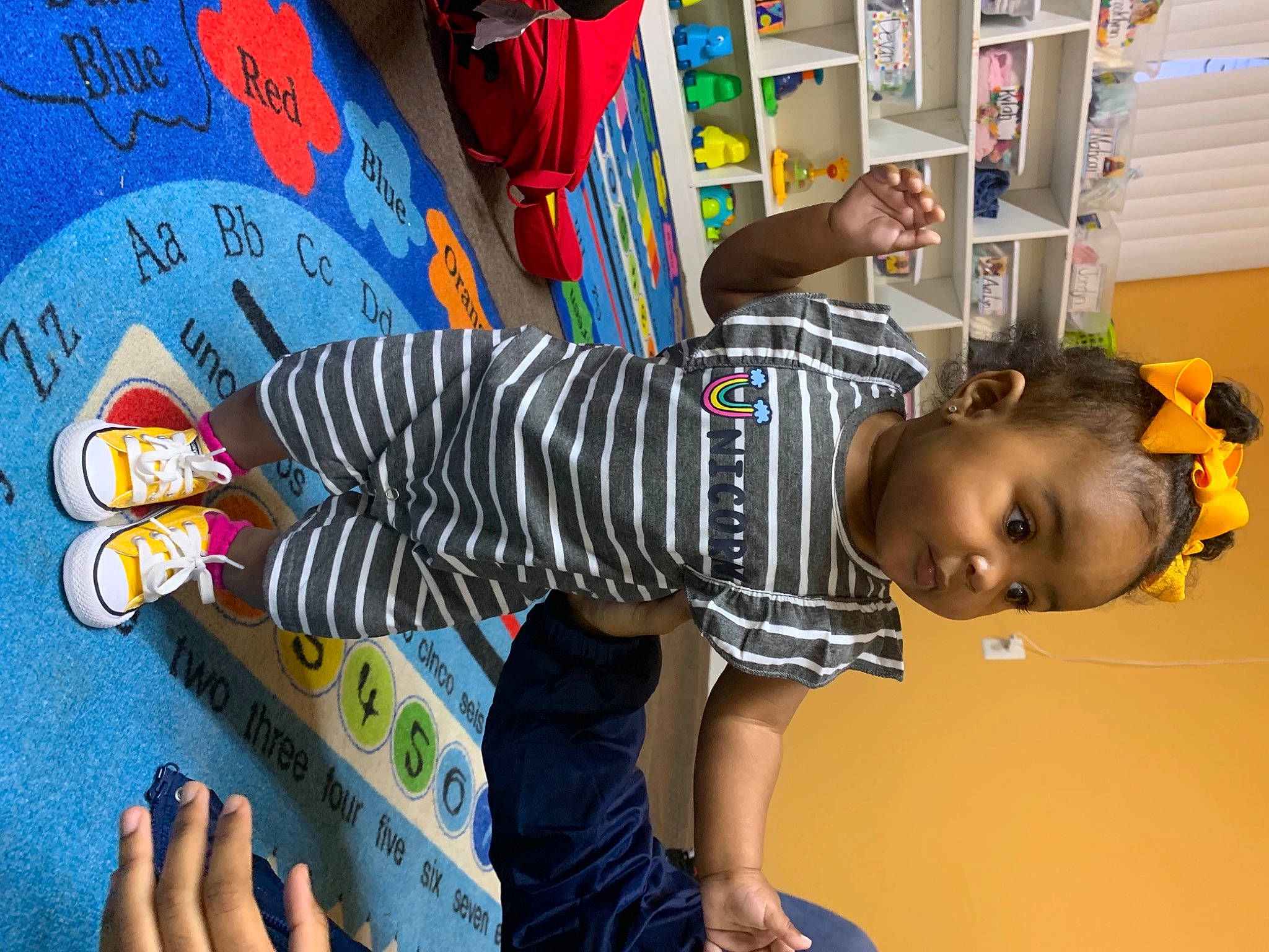 Asiah joined the competition — help win amazing prizes! baby_toddler_clothing, bookcase, child, ear, foot, nail, person, shelf, shelving, sock, toddler