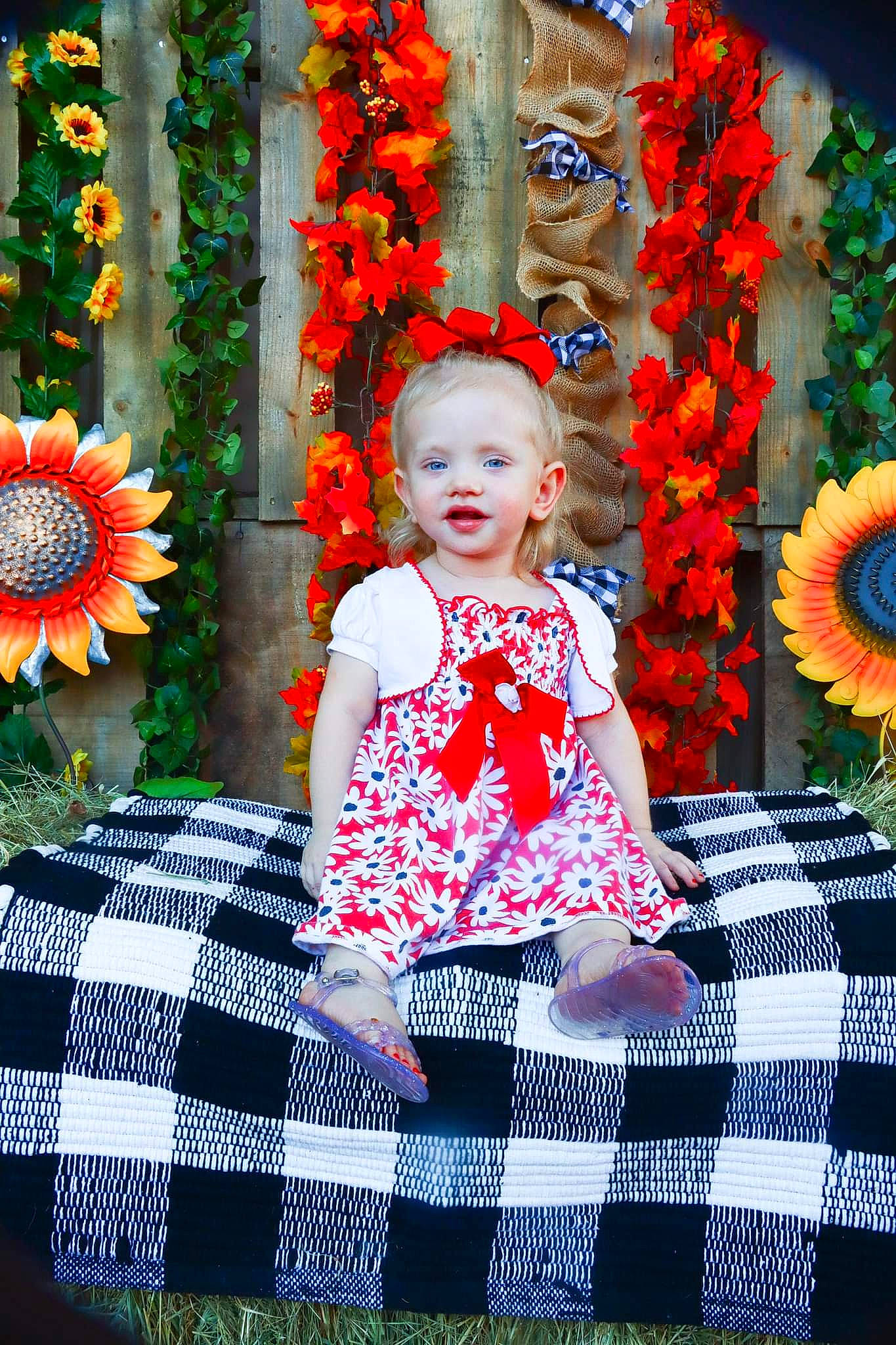 Isabella is registered to the contest to win money with this photo: baby_toddler_clothing, beauty, botany, eye, facial_expression, flower, fun, happy, leaf, orange, organ, people_in_nature, person, petal, photograph, plant, red, smile, summer, textile