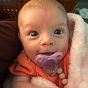 Isla joined the competition — help win amazing prizes! baby, infant, pacifier, blanket, closeup, big_eyes, cute, newborn, portrait, pink_blanket, orange_outfit, face, hand, cozy, soft_texture, wicker_background, brown_cushion, indoor, gaze, smile