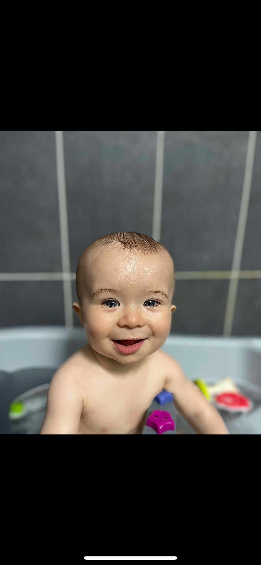 Maël a rejoint le concours — aidez-le/la à gagner de superbes lots ! baby, child, smiling, bath, water, toy, blue_eyes, happy, skin, head, face, arm, tiled_wall, bathroom, cute, infant, playful, wet, person, young