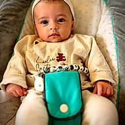 Maria participe au concours pour gagner de l'argent avec cette photo : baby, infant, headband, beige_clothing, turquoise_pouch, beads, baby_seat, cushion, heart_pattern, calm, portrait, closeup, indoor, cute, child, small_hands, soft_lighting, comfortable, seated, looking_at_camera