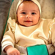 Maria participe au concours pour gagner de l'argent avec cette photo : baby, infant, smiling, headband, bow, onesie, baby_seat, car_seat, harness, cute, cheeks, big_eyes, portrait, closeup, soft_lighting, warm_tones, clothing, hand, buckle, cozy