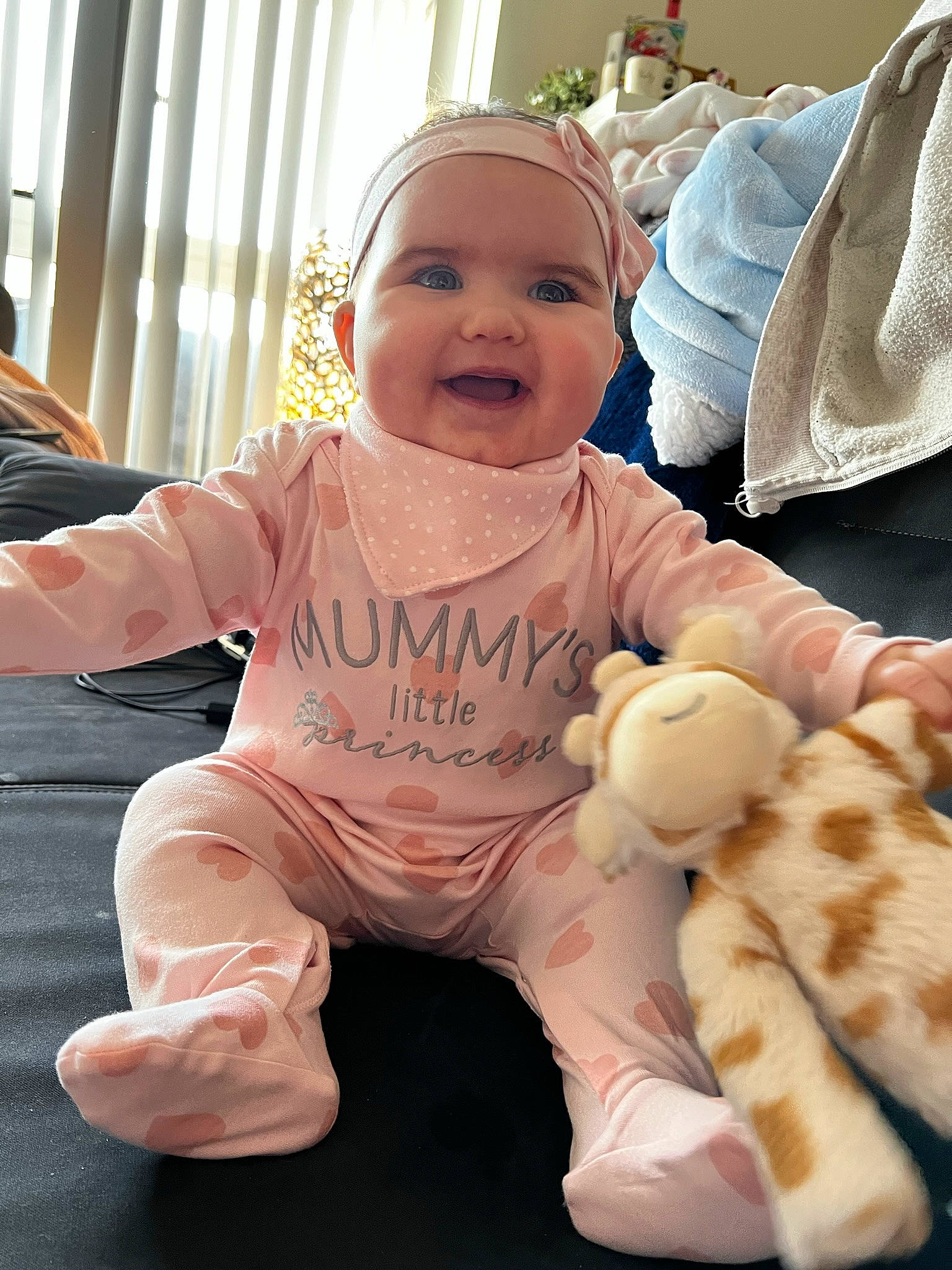 Delilah joined the competition — help win amazing prizes! baby, baby_toddler_clothing, child, comfort, curtain, finger, foot, fun, gesture, happy, headwear, interaction, joy, mammal, person, pink, product, sitting, skin, smile