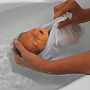 Constance participe au concours pour gagner de l'argent avec cette photo : baby, infant, swaddled, hands, bathtub, water, towel, bath, person, skin, white_cloth, relaxation, newborn, care, cleaning, gentle, indoor, parent, closeup, human