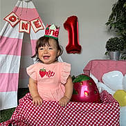 Amanda is registered to the contest to win money with this photo: baby, child, birthday, first_birthday, crown, pink_dress, strawberry, balloon, number_one, tent, inflatable_flower, checkered_cloth, smiling, happy, indoor, plant, decorations, celebration, person, festive