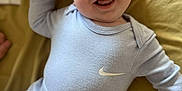 Arlo-Lee joined the competition — help win amazing prizes! baby, smiling, infant, clothing, nike, onesie, pants, happy, lying_down, blanket, child, cute, portrait, face, human, apparel, sleeves, feet, indoor, young