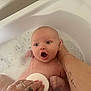 Arlo-Lee is registered to the contest to win money with this photo: baby, bath, bubbles, foam, water, tub, hand, tattoo, skin, child, infant, support, expression, surprised, cleaning, parent, care, cute, indoors, relaxation