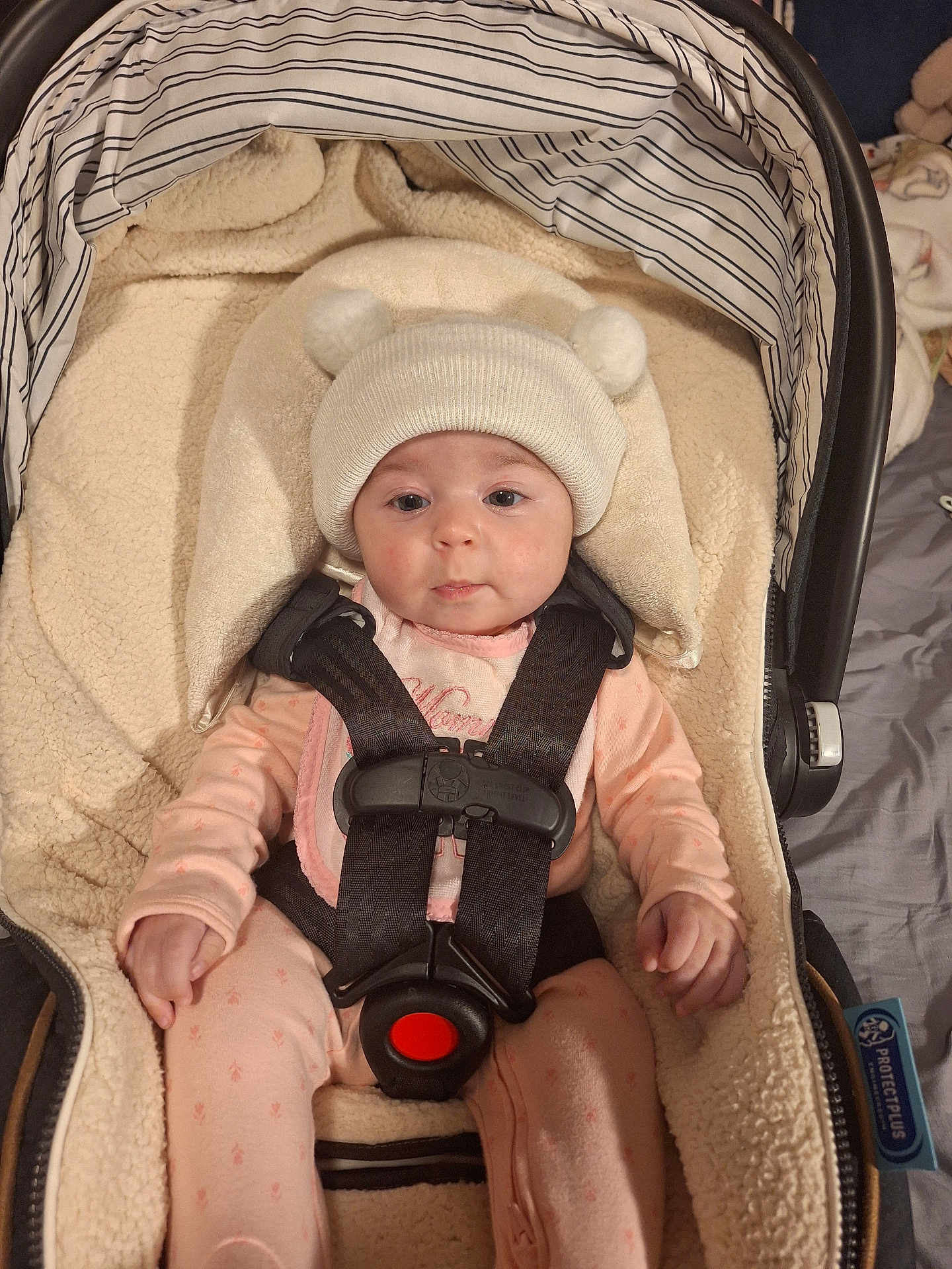 Haylee M is registered to the contest to win money with this photo: baby, infant, car_seat, hat, pink_pajamas, face, child, straps, safety_harness, cute, indoors, blanket, soft, cozy, person, newborn, headwear, clothing, seated, expression